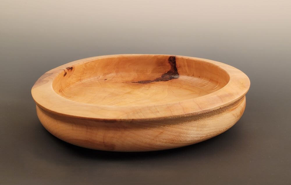 Flat maple bowl with shaped lip.